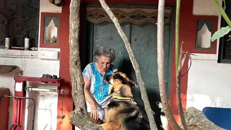 Almrita Patel plays with her dog outside her farmhouse