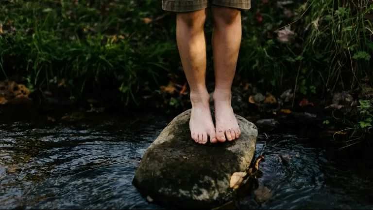 A child balances on a rock in a river 