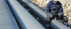 عامل يتفقد انبوبا للنفط