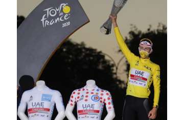 Tour de France winner Slovenia's Tadej Pogacar, wearing the overall leader's yellow jersey, celebrates on the podium after the twenty-first and last stage of the Tour de France cycling race over 122 kilometers (75.8 miles)