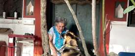 Almrita Patel plays with her dog outside her farmhouse