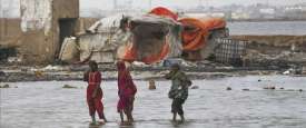 Pakistani flood victims cross sea water